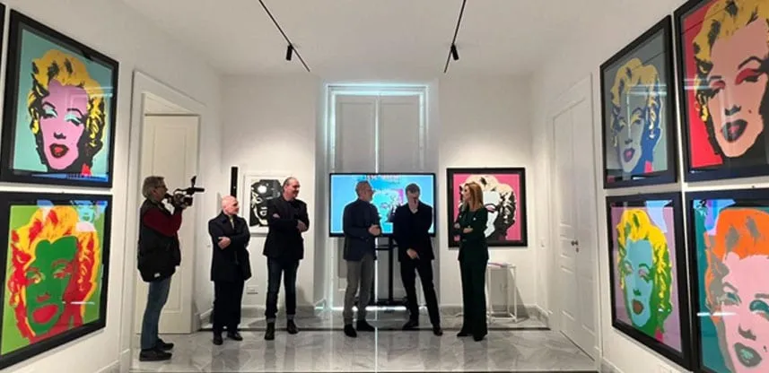 Una sala della mostra con le serigrafie di Marilyn alle pareti e i visitatori