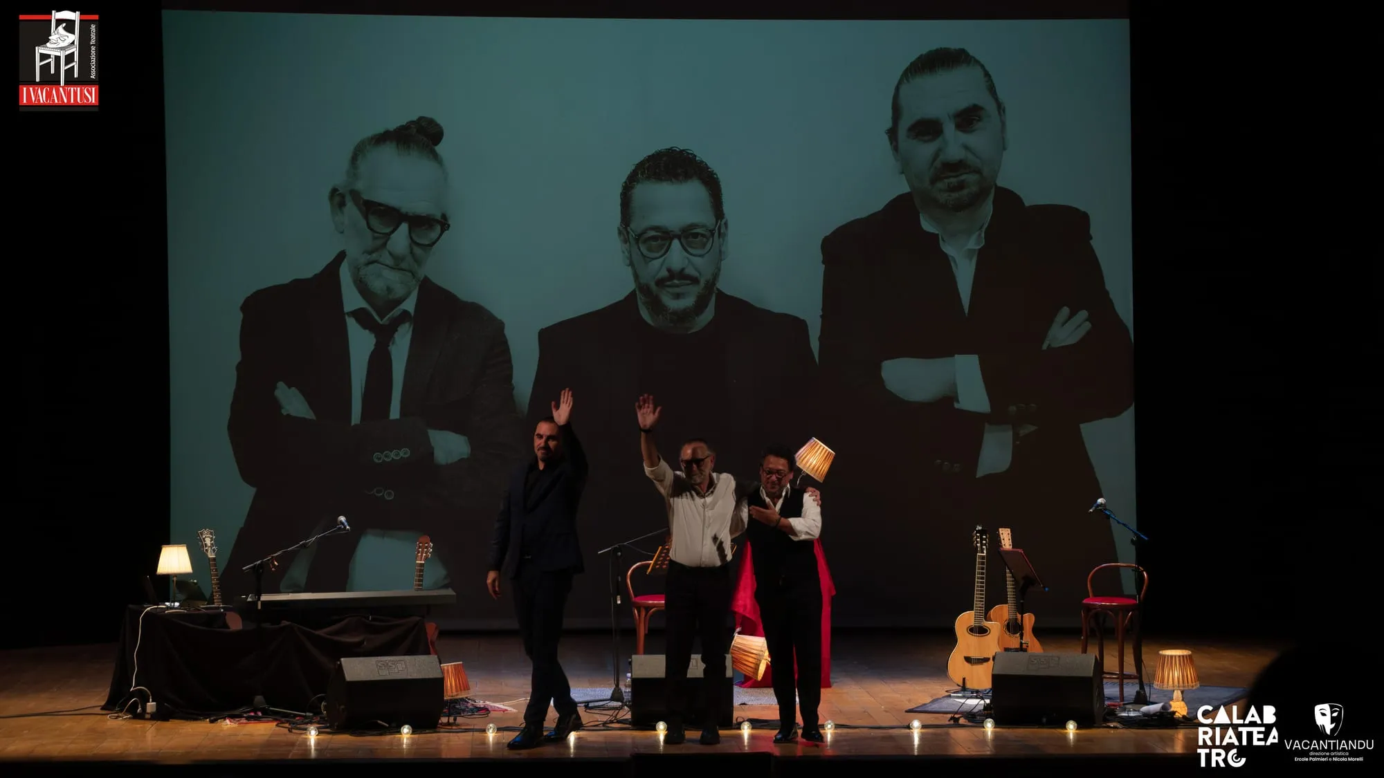 I tre interpreti sul palco davanti alla loro foto proiettata