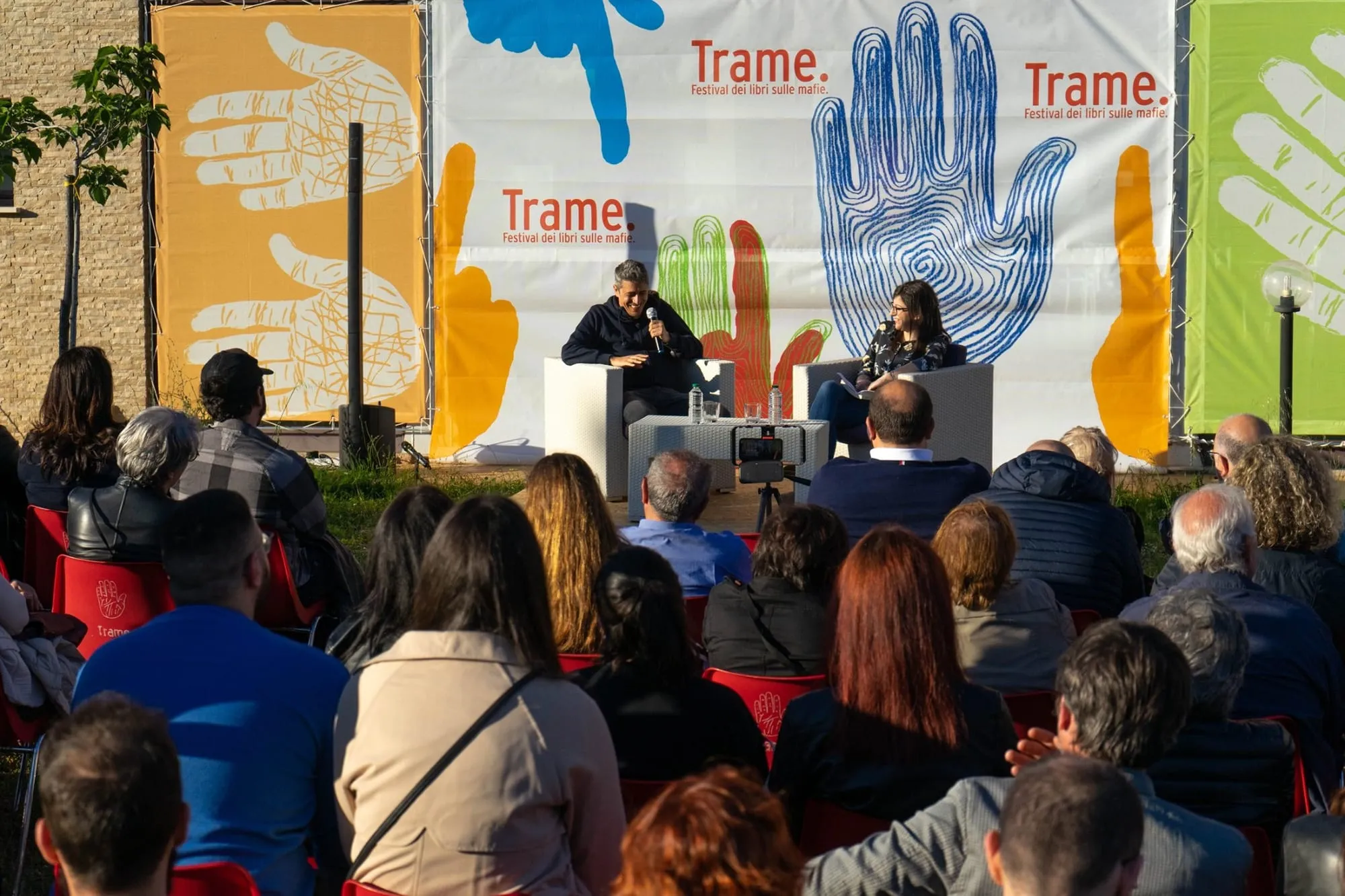 Incontro con il pubblico davanti ai pannelli colorati di Trame