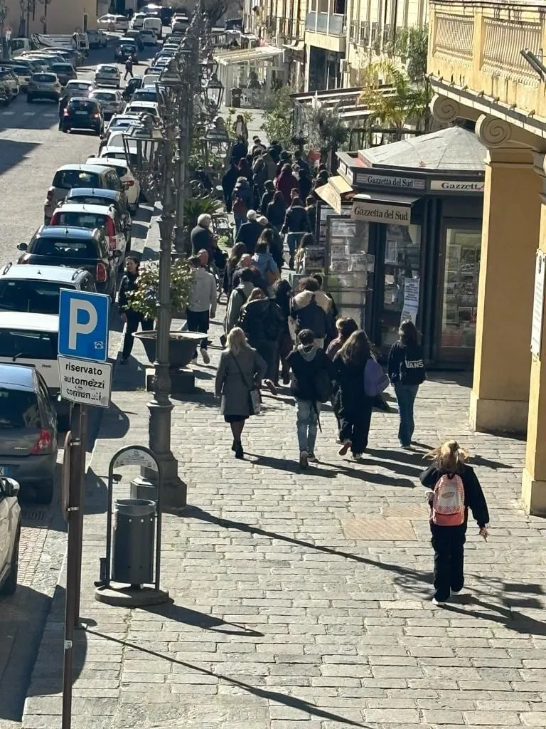 Visitatori in fila lungo la strada verso il palazzo